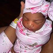 Amorah is registered to the contest to win money with this photo: newborn, baby, infant, swaddle, pink, headwrap, floral, sleeping, closeup, person, human, skin, face, hand, hospital, wristband, adult, cradle, comfort, tenderness