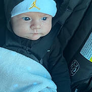 Kylo is registered to the contest to win money with this photo: baby, infant, car_seat, blanket, hood, hat, jumpman_logo, buckle, seatbelt, blue_eyes, hand, fingers, black_clothing, closeup, portrait, newborn, cozy, soft_texture, cute, pacifier