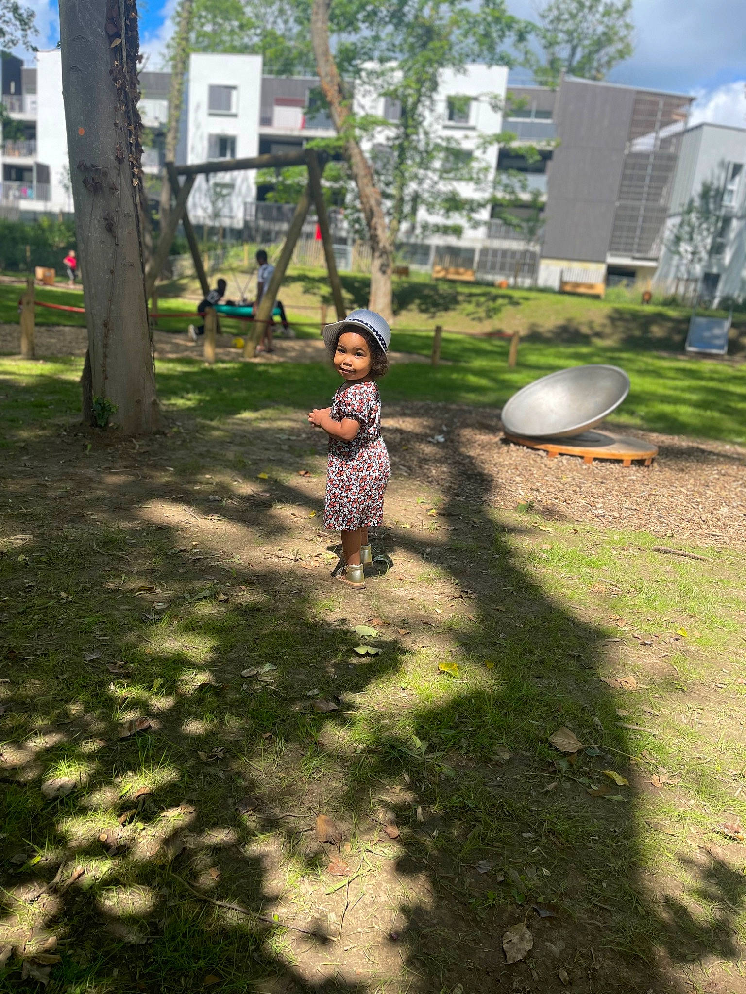 Aïcha a rejoint le concours — aidez-le/la à gagner de superbes lots ! asphalt, botany, building, city, grass, headwear, land_lot, landscape, lawn, leisure, nature, people_in_nature, person, plant, public_space, recreation, road, sidewalk, sunlight, tree