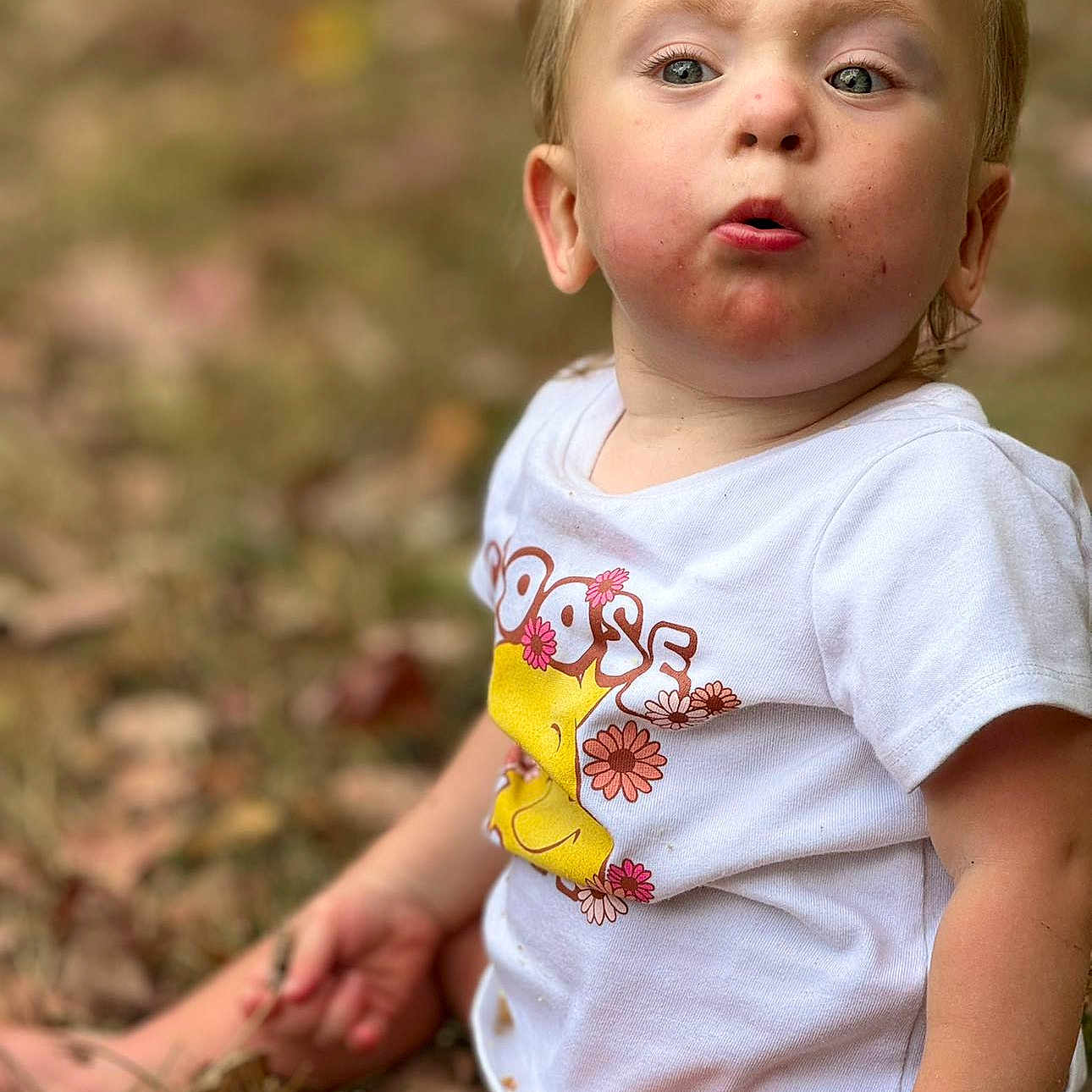 Willow is registered to the contest to win money with this photo: baby, blonde, bodypart, clothing, face, finger, frown, grass, hair, hand, head, people, person, photography, plant, portrait, sad, sitting, sleeve, t_shirt