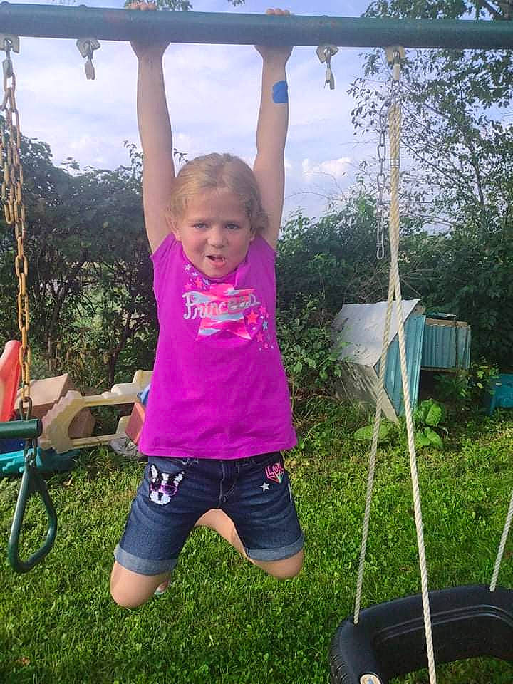 Aubrie is registered to the contest to win money with this photo: bicycle_wheel, cloud, fun, grass, green, happy, leisure, nature, people_in_nature, person, plant, public_space, recreation, shorts, sky, summer, swing, t_shirt, toddler, tree