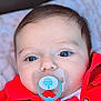 baby, pacifier, red_jacket, closeup, face, eyes, infant, child, blanket, cute, portrait, young, skin, clothing, babywear, lying_down, indoors, soft_light, head, expression