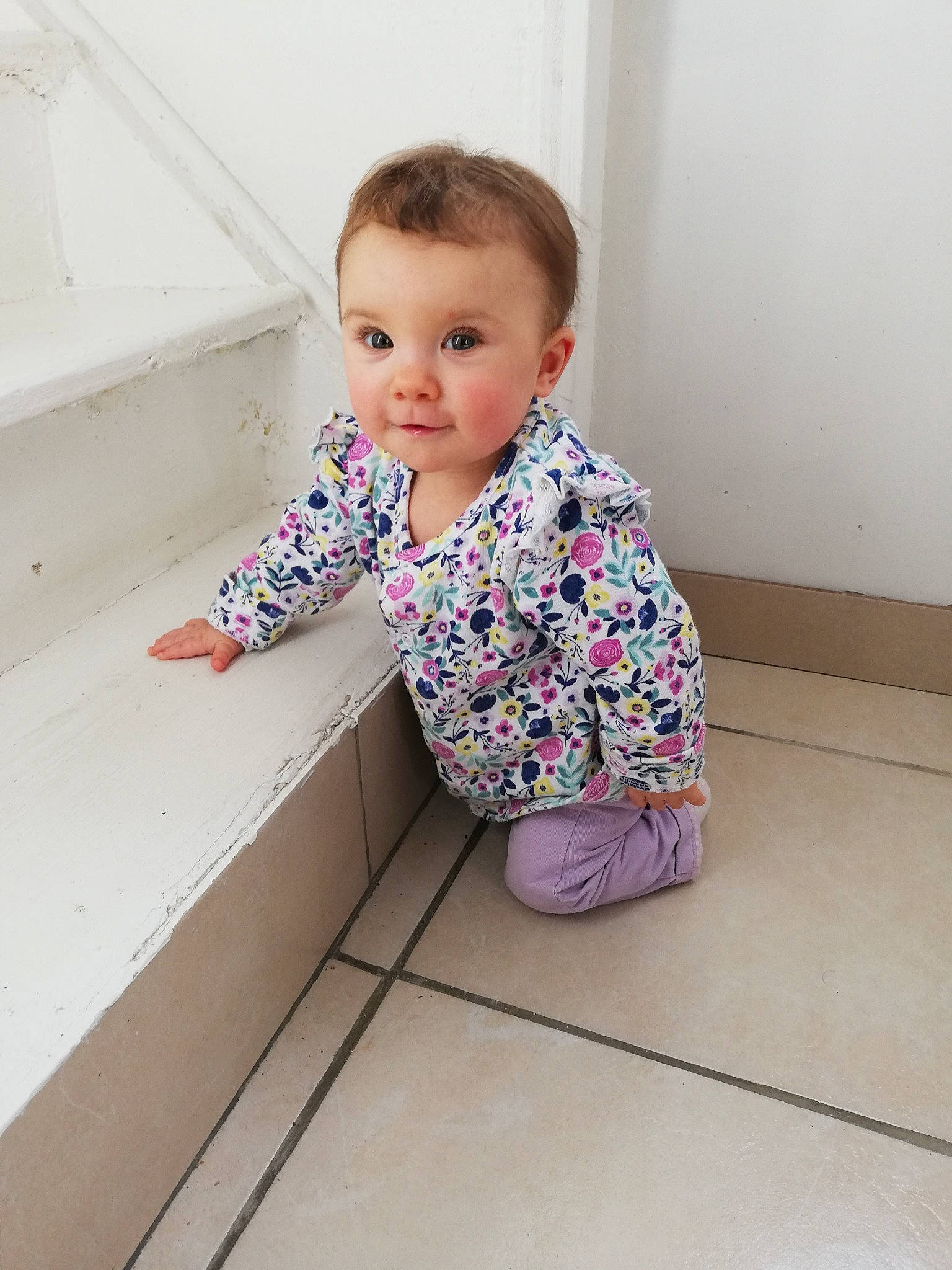 Lyanna participe au concours pour gagner de l'argent avec cette photo : baby, baby_toddler_clothing, cheek, child, face, floor, flooring, hardwood, head, magenta, outerwear, pattern, person, pink, rectangle, sitting, sleeve, t_shirt, toddler, wood