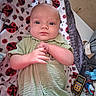 Michael Lewis is registered to the contest to win money with this photo: baby, infant, blanket, ladybug_pattern, green_clothing, face, hands, pacifier, walkie_talkie, toy, diaper, indoor, child, person, cute, lying_down, closeup, portrait, soft_texture, comfort