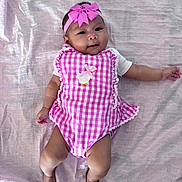 Sayda is registered to the contest to win money with this photo: baby, infant, child, pink_bow, headband, checkered_outfit, duck_applique, blanket, lying_down, cute, soft_texture, smiling, arms_spread, legs_spread, indoors, skin, person, baby_clothing, adorable, portrait