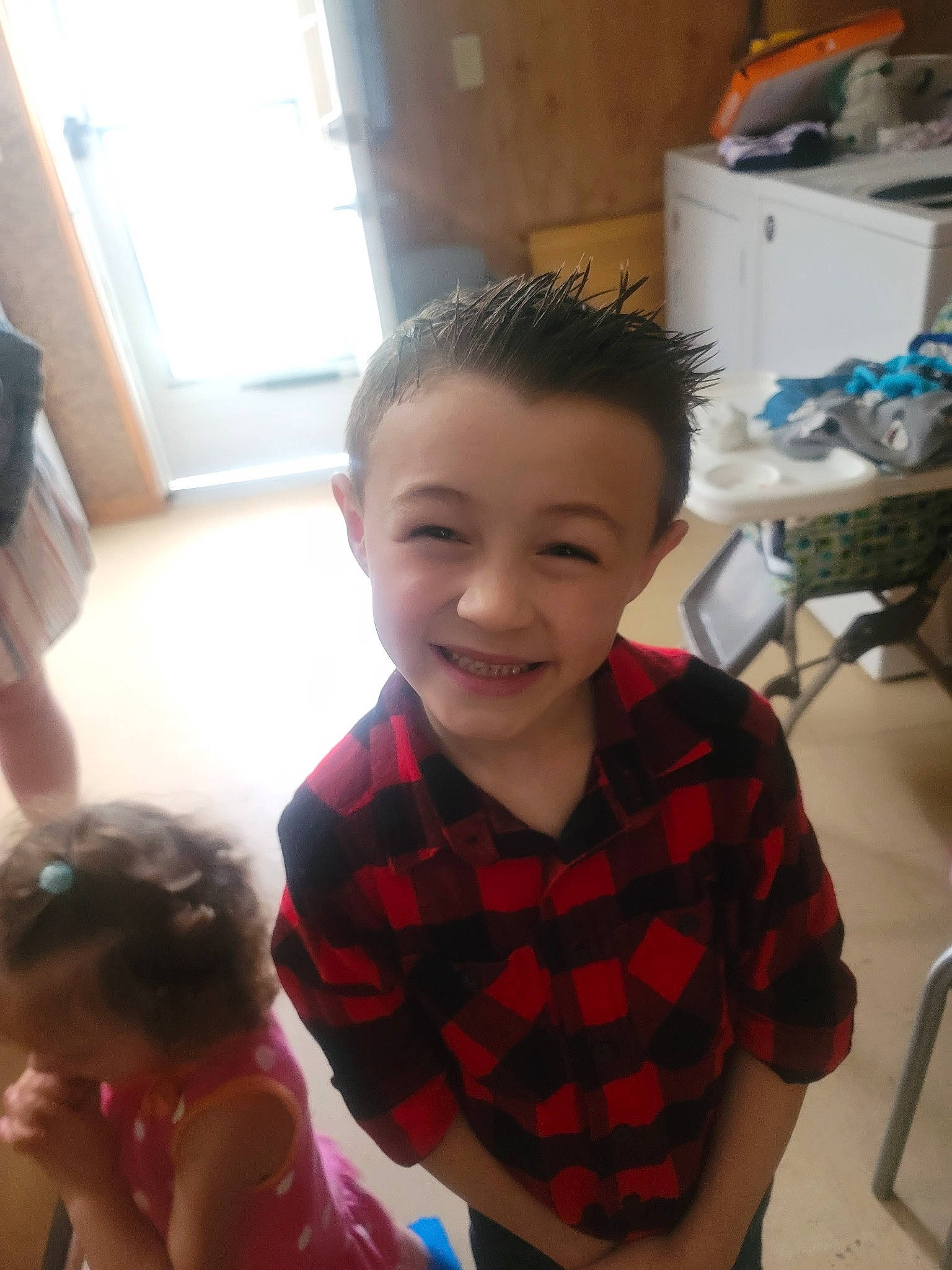 Brantley is registered to the contest to win money with this photo: chair, child, chin, ear, finger, fun, gesture, happy, joy, neck, nose, person, plaid, shoulder, sitting, skin, smile, t_shirt, tartan, thumb