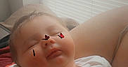 Sofia Donahue joined the competition — help win amazing prizes! baby, infant, child, sleeping, face, portrait, indoors, window, blinds, lap, adult, hand, onesie, clothing, cozy, sitting, relaxed, heart_decoration, closeup, family