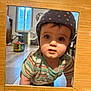Youenn a rejoint le concours — aidez-le/la à gagner de superbes lots ! baby, child, helmet, striped_shirt, indoor, wooden_frame, curious, face, crawling, toy, floor, window, clock, furniture, home, person, headwear, expression, playtime, colorful