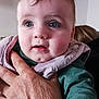 baby, child, hand, face, blue_eyes, clothing, pink_bib, green_shirt, portrait, indoor, person, skin, young_child, holding, closeup, expression, human, head, cheeks, background_photos