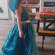 Rafaëlle participe au concours pour gagner de l'argent avec cette photo : child, dress, princess_costume, blue_dress, green_lace, gold_accent, indoor, wooden_floor, table, toy_storage, toys, furniture, young_child, costume, playroom, side_view, long_dress, child_playing, home, floor