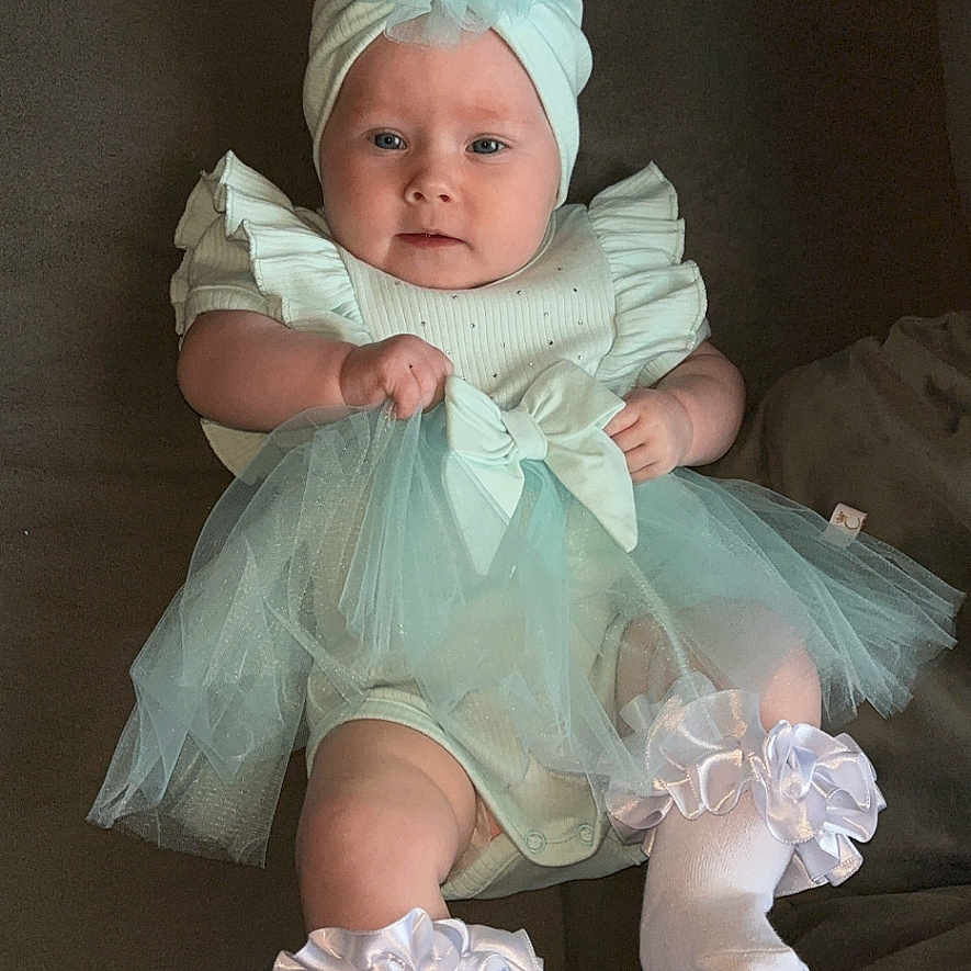 Rainy-Mae joined the competition — help win amazing prizes! baby, bodypart, bonnet, cap, clothing, costume, couch, dress, face, finger, furniture, glove, hand, hat, head, newborn, person, photography, portrait, sitting
