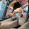 Udaya is registered to the contest to win money with this photo: adult, blue_dress, car, car_interior, child, curly_hair, daylight, family, fast_food, fries, happy, indoors, leather_seats, portrait, seated, selfie, smiling, toddler, vehicle, woman