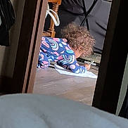 Udaya joined the competition — help win amazing prizes! blanket, candid, child, colorful_clothing, couch, crawling, cup, curly_hair, doorway, family_scene, home, indoor, living_room, paper, patterned_outfit, portrait, toddler, toy, tray_table, wooden_floor