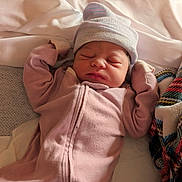 Leomi joined the competition — help win amazing prizes! baby, bed, blanket, clothing, couch, cozy, eyes_closed, face, indoor, infant, newborn, peaceful, photography, pillow, pink_onesie, portrait, sleeping, striped_hat, warm_lighting, wood_floor