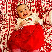 Margot participe au concours pour gagner de l'argent avec cette photo : baby, infant, child, smiling, laughing, red_dress, white_tights, festive_blanket, snowflake_pattern, holiday_outfit, cozy_blanket, rosy_cheeks, cute, portrait, lying_down, hand, eyes, hair, indoor, soft_texture