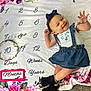 Ariyah joined the competition — help win amazing prizes! baby, child, smiling, denim_dress, boots, headband, milestone_blanket, floral_pattern, numbers, words, carpet, cute, happy, portrait, indoors, infant, waving, clothing, face, person