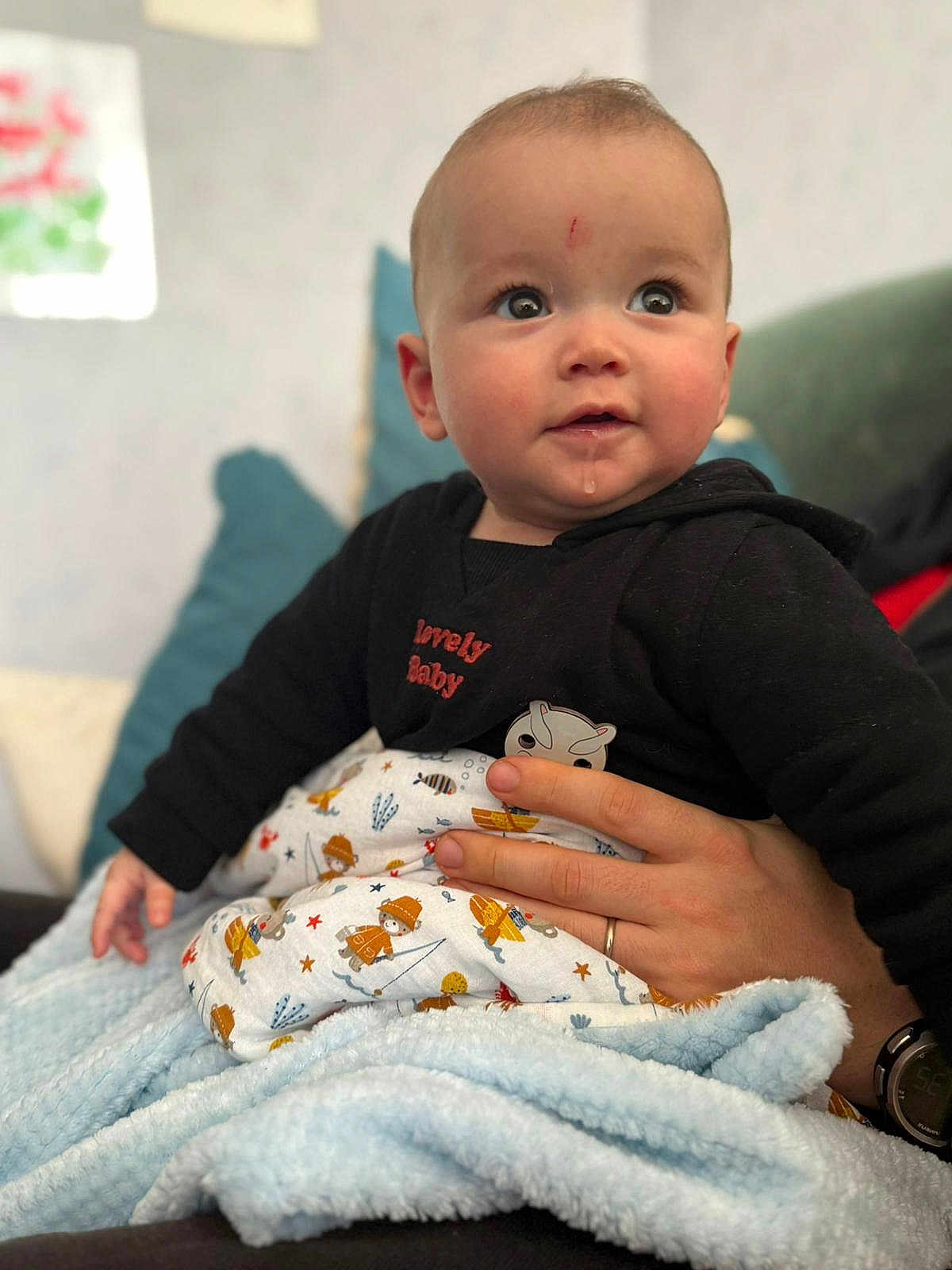 Louis a rejoint le concours — aidez-le/la à gagner de superbes lots ! baby, infant, child, blanket, hand, clothing, face, drool, curious, indoor, person, cute, soft, holding, watch, fabric, seated, expression, black_clothing, patterned_blanket