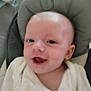 baby, infant, smile, face, close_up, cushion, seat, blanket, child, indoors, person, happy, young, head, skin, eyes, mouth, clothing, baby_seat, newborn