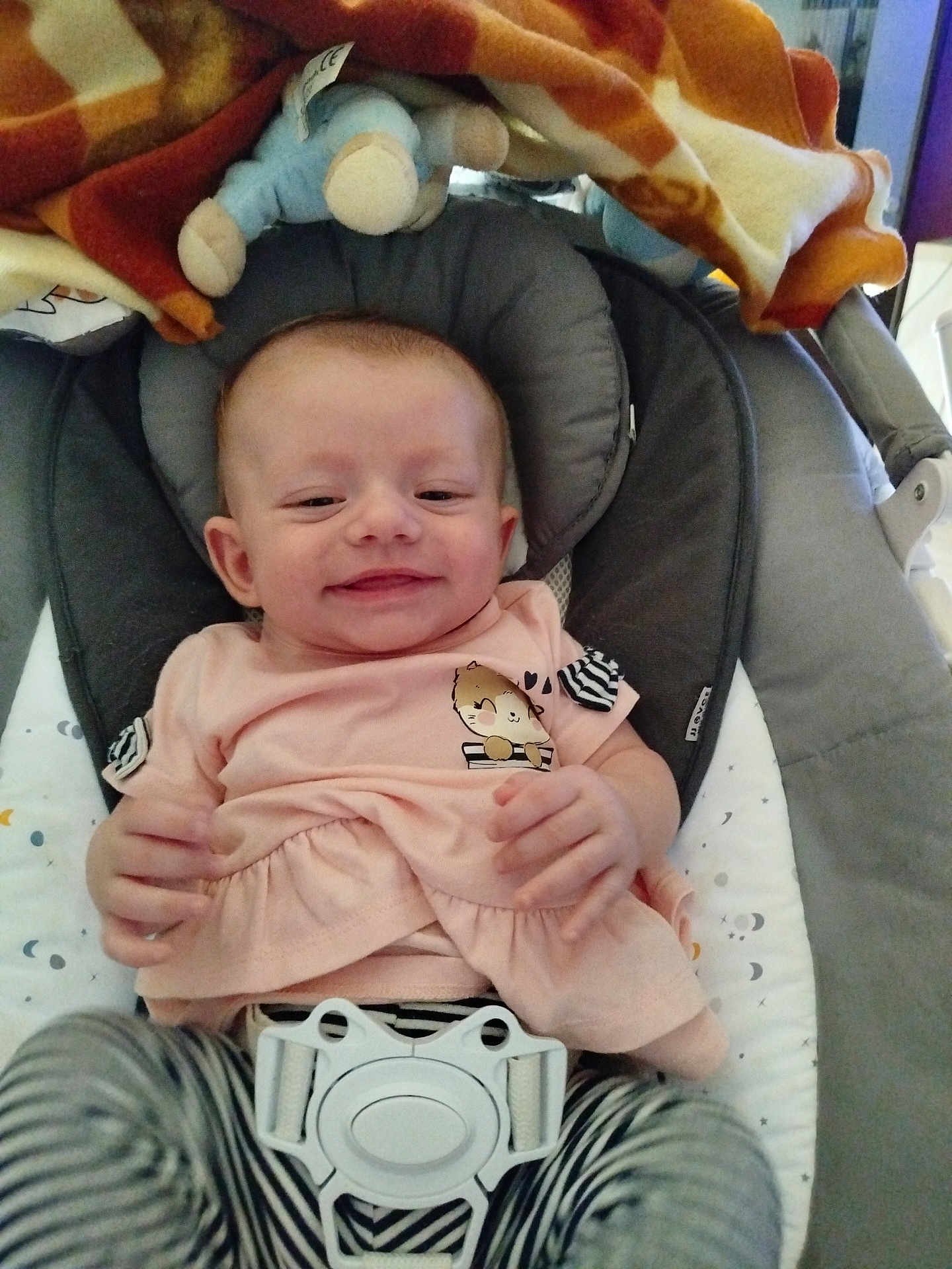 Inaya participe au concours pour gagner de l'argent avec cette photo : baby, smiling, infant, baby_rocker, pink_shirt, striped_pants, plush_toy, blanket, cushion, face, person, indoor, child, happy, clothing, seat, comfort, cute, head, resting