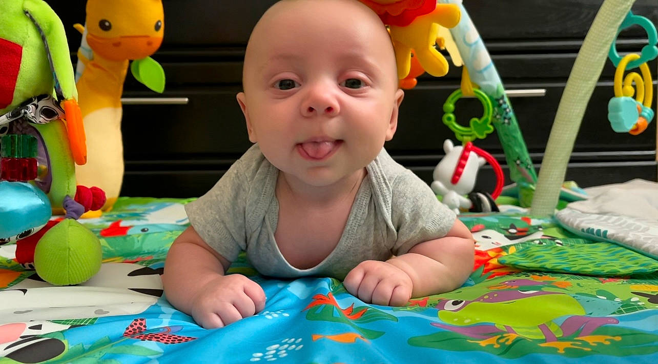 Haiden is registered to the contest to win money with this photo: adaptation, baby, baby_playing_with_toys, baby_toddler_clothing, cheek, child, flooring, fun, green, happy, human_body, leisure, nose, organ, person, product, smile, snapshot, toddler, toy