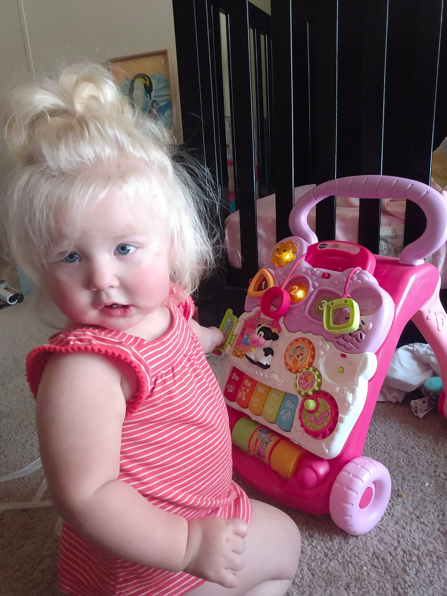 Karina is registered to the contest to win money with this photo: arm, baby, baby_toddler_clothing, cheek, child, fun, grass, happy, head, magenta, mammal, pattern, person, pink, purple, riding_toy, sitting, toddler, toy, toy_vehicle