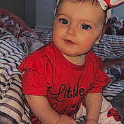 Luna participe au concours pour gagner de l'argent avec cette photo : baby, child, red_clothing, headband, ladybug_pattern, striped_bedspread, indoor, portrait, cute, smiling, sitting, person, toddler, hand, face, hair, playful, cozy, bedroom, fashion