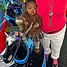 baby, child, carousel, horse, arcade, amusement_ride, person, adult, colorful, clothing, shoes, toy, playful, indoor, entertainment, face, jewelry, plaid_skirt, sweater, curly_hair