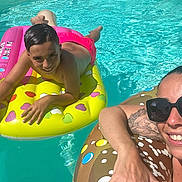 Rafaël a rejoint le concours — aidez-le/la à gagner de superbes lots ! child, adult, swimming_pool, float, inflatable, water, sunlight, swimwear, smile, sunglasses, tattoo, relaxation, summer, fun, outdoor, leisure, vacation, bright_colors, heart_shapes, donut_float
