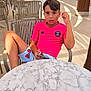 Rafaël participe au concours pour gagner de l'argent avec cette photo : boy, child, outdoor, cafe, chair, table, smartphone, pink_shirt, watermelon_shorts, summer, sunlight, relaxing, casual, portrait, person, seat, expression, vacation, leisure, daylight