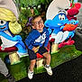 Côme participe au concours pour gagner de l'argent avec cette photo : child, boy, glasses, smile, nike_hoodie, shorts, sneakers, smurfs, cartoon_characters, cutouts, indoor, carpet, forest_background, snack, happy, posing, playful, colorful, fun, event