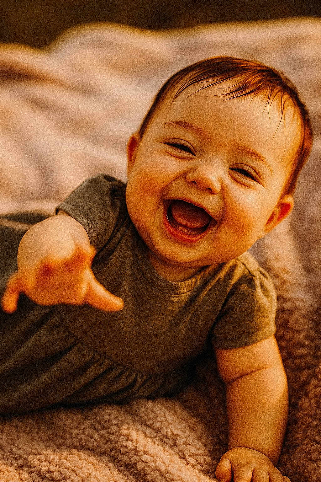 Liliana joined the competition — help win amazing prizes! baby, smiling, laughing, child, happy, infant, cute, portrait, reaching_hand, blanket, cozy, warm_lighting, soft_texture, indoor, casual_clothing, short_hair, closeup, face, expression, toddler