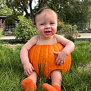 Josiah is registered to the contest to win money with this photo: autumn, baby, booties, child, face, family_photo, garden, grass, halloween, happy, infant, knitted_shoes, nature, orange, outdoor, portrait, pumpkin, pumpkin_costume, sitting, smiling