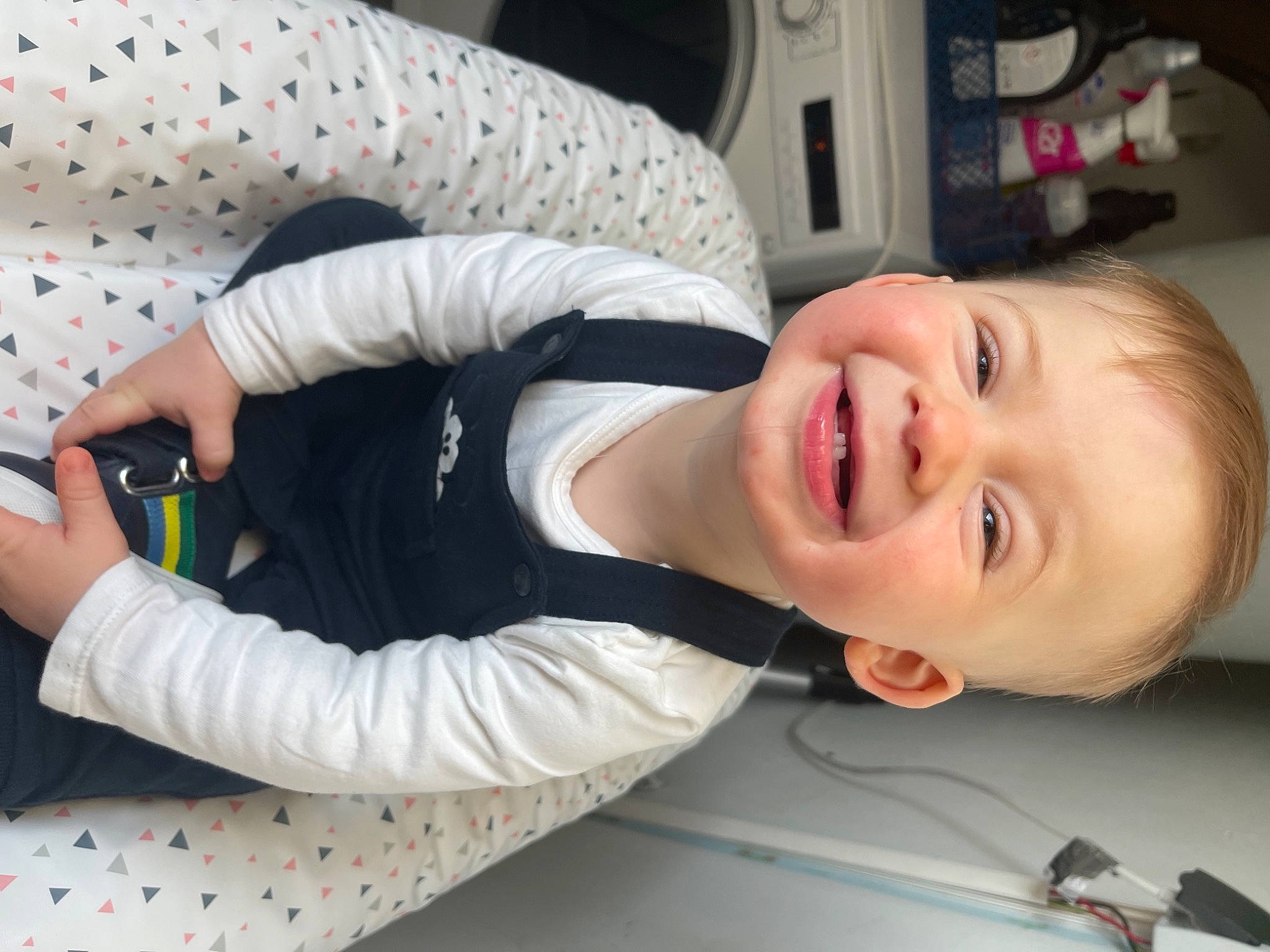 Tylio participe au concours pour gagner de l'argent avec cette photo : baby, baby_laughing, baby_products, baby_toddler_clothing, cheek, child, comfort, elbow, finger, fun, happy, joy, laugh, mouth, nose, person, room, sitting, sleeve, smile