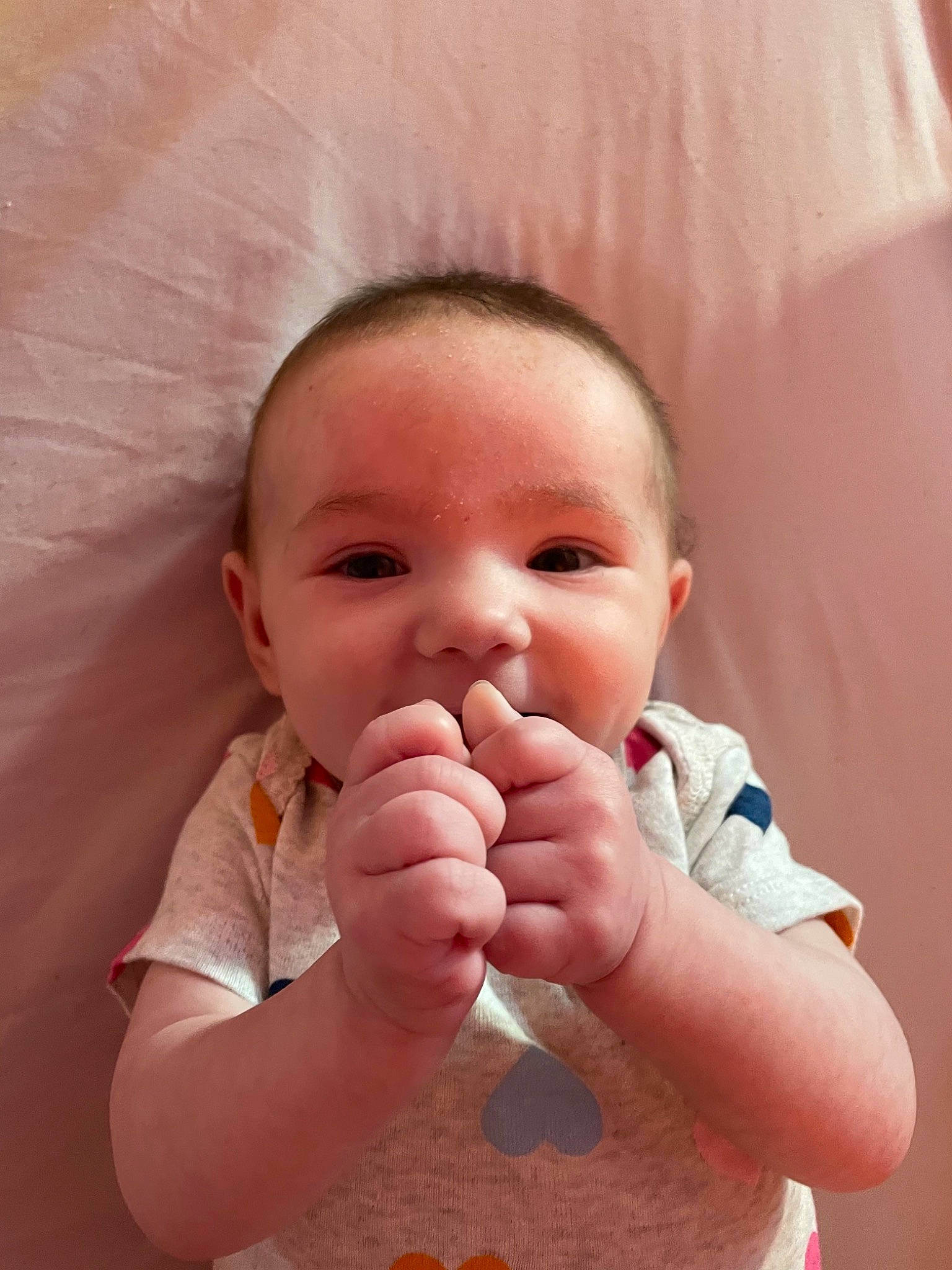 Saphira is registered to the contest to win money with this photo: baby, baby_toddler_clothing, cheek, comfort, eyelash, finger, gesture, hand, happy, lip, mouth, nail, neck, nose, person, pink, skin, sleeve, thumb, toddler
