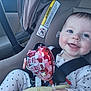 baby, infant, child, car_seat, seatbelt, valentine_balloon, smiling, blue_eyes, polka_dot_pajamas, happy, cheeks, hand, car_interior, warning_label, closeup, portrait, sitting, toy, window, skin