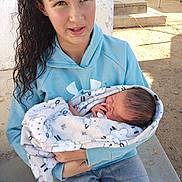Caden joined the competition — help win amazing prizes! child, baby, newborn, blanket, hoodie, curly_hair, outdoor, sunlight, concrete, holding, toddler, person, infant, casual_clothing, curious, caring, portrait, resting, wrapped, young