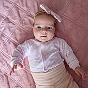 Melissa participe au concours pour gagner de l'argent avec cette photo : baby, child, infant, pink, headband, bow, striped_pants, quilt, bed, blanket, soft_texture, looking_at_camera, cute, clothing, portrait, hand, lying_down, indoors, person, adorable