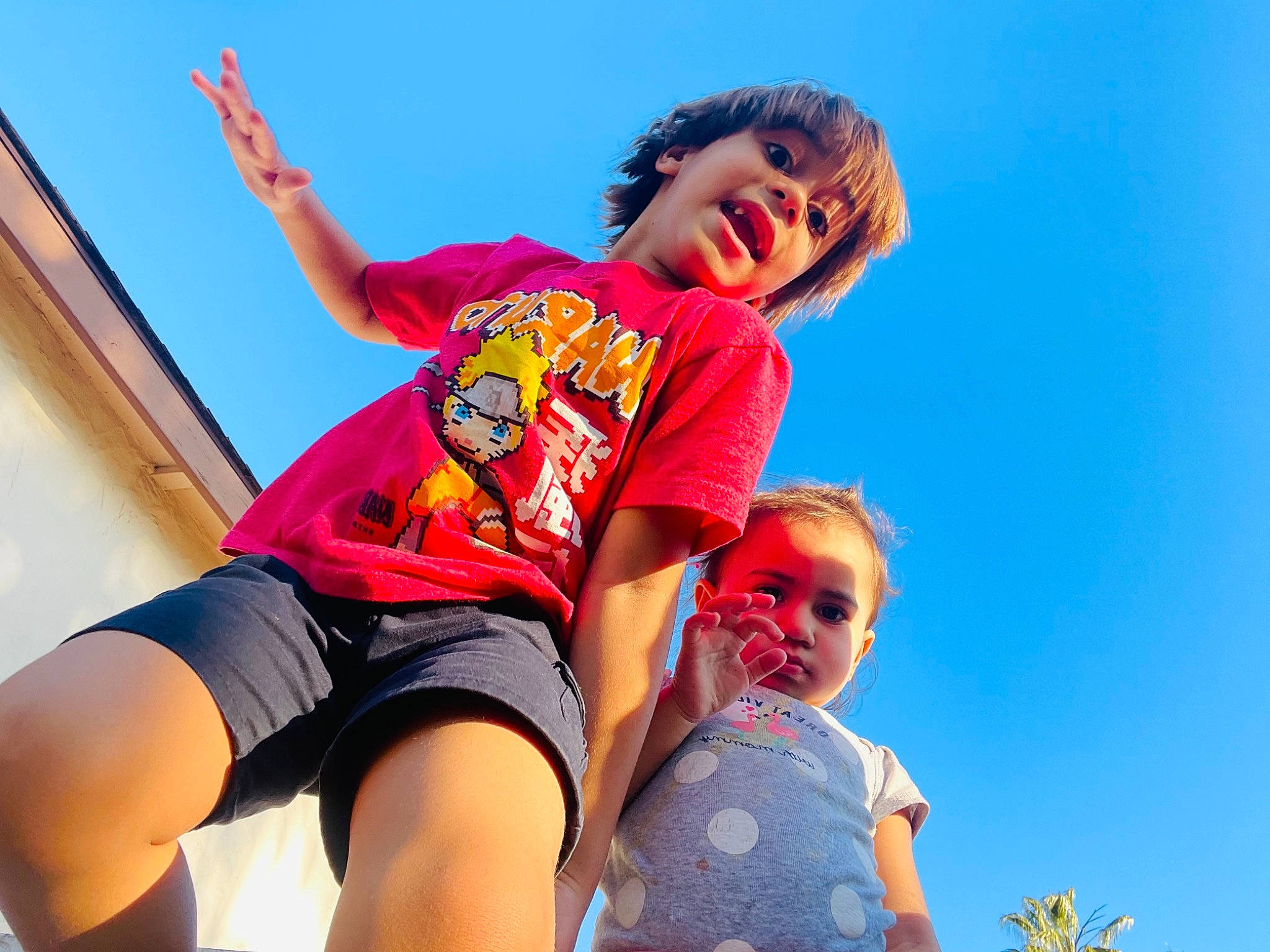 Victor is registered to the contest to win money with this photo: arm, event, eyewear, fun, gesture, happy, human_leg, leisure, people, people_in_nature, person, recreation, shorts, sitting, sky, summer, sunlight, t_shirt, thigh, toddler