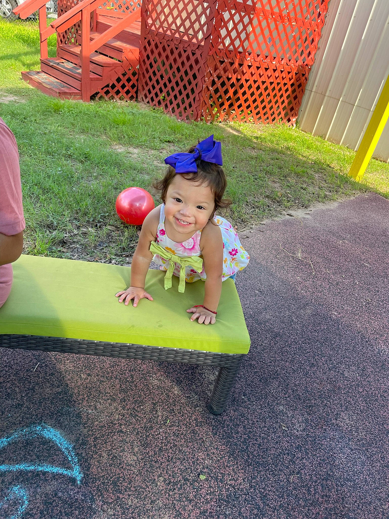 Aileen is registered to the contest to win money with this photo: asphalt, baby_toddler_clothing, child, city, fun, grass, happy, joy, lawn, leisure, magenta, outdoor_furniture, outdoor_play_equipment, person, pink, play, public_space, recreation, sitting, smile