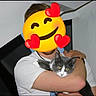 Arya participe au concours pour gagner de l'argent avec cette photo : person, cat, indoor, hugging, gray_cat, white_cat, emoji_overlay, white_shirt, wooden_beam, wall, yellow_eyes, pet, domestic_animal, human, arm, holding, facial_obscured, domestic_cat, cute, animal_companion