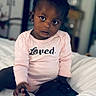 Kailani is registered to the contest to win money with this photo: toddler, child, infant, baby, pink_onesie, bed, smartphone, curious, indoor, portrait, person, cute, clothing, face, looking, sitting, home, furniture, earrings, expression