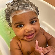 Atlantis is registered to the contest to win money with this photo: baby, child, bath, foam, shampoo, curly_hair, smile, happy, water, skin, cute, toddler, closeup, playful, indoors, person, head, face, hands, clean