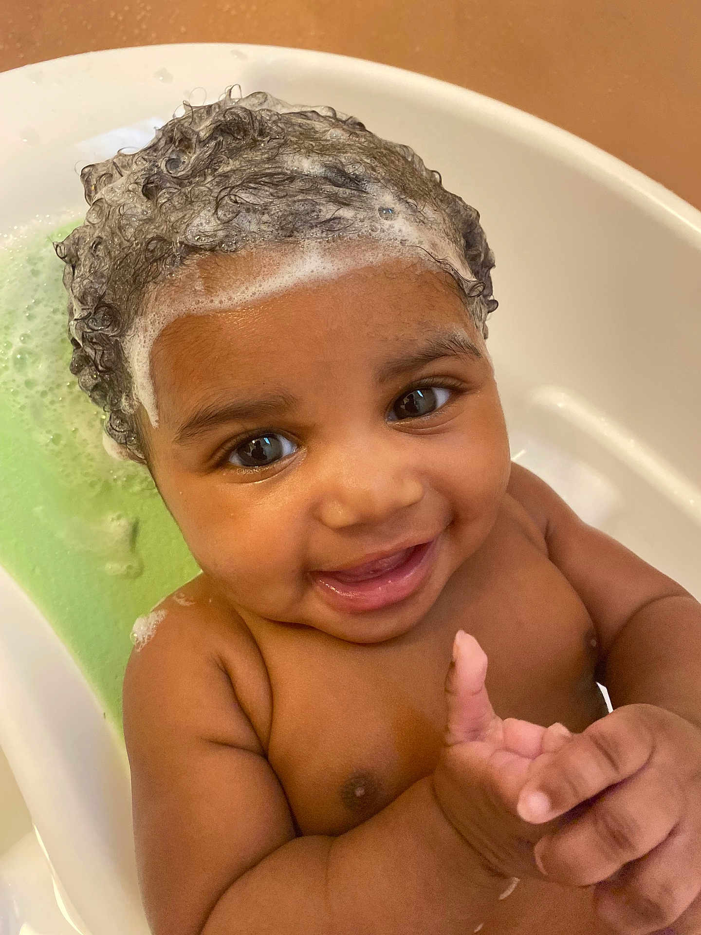 Atlantis is registered to the contest to win money with this photo: baby, child, bath, foam, shampoo, curly_hair, smile, happy, water, skin, cute, toddler, closeup, playful, indoors, person, head, face, hands, clean