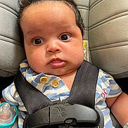 Marceau is registered to the contest to win money with this photo: baby, infant, car_seat, seatbelt, pacifier, striped_shirt, baseball_patch, closeup, child, cute, face, expression, indoors, safety, clothing, head, person, newborn, young_child, portrait