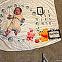Marceau is registered to the contest to win money with this photo: baby, blanket, carpet, child, clothing, colorful, day, feet, floor, infant, milestone, month, person, plush, sleeping, soft, toy, winnie_the_pooh, young, lying