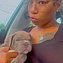 person, puppy, dog, car, glasses, braids, jewelry, tattoo, black_shirt, hand, window, seat, portrait, cute, wrinkled_dog, sleepy, indoor, closeup, animal, pet