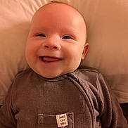 Leon joined the competition — help win amazing prizes! baby, smiling, infant, face, pillow, clothing, brown, cute, portrait, happy, child, indoors, soft, cozy, tag, closeup, young, person, lying, expression