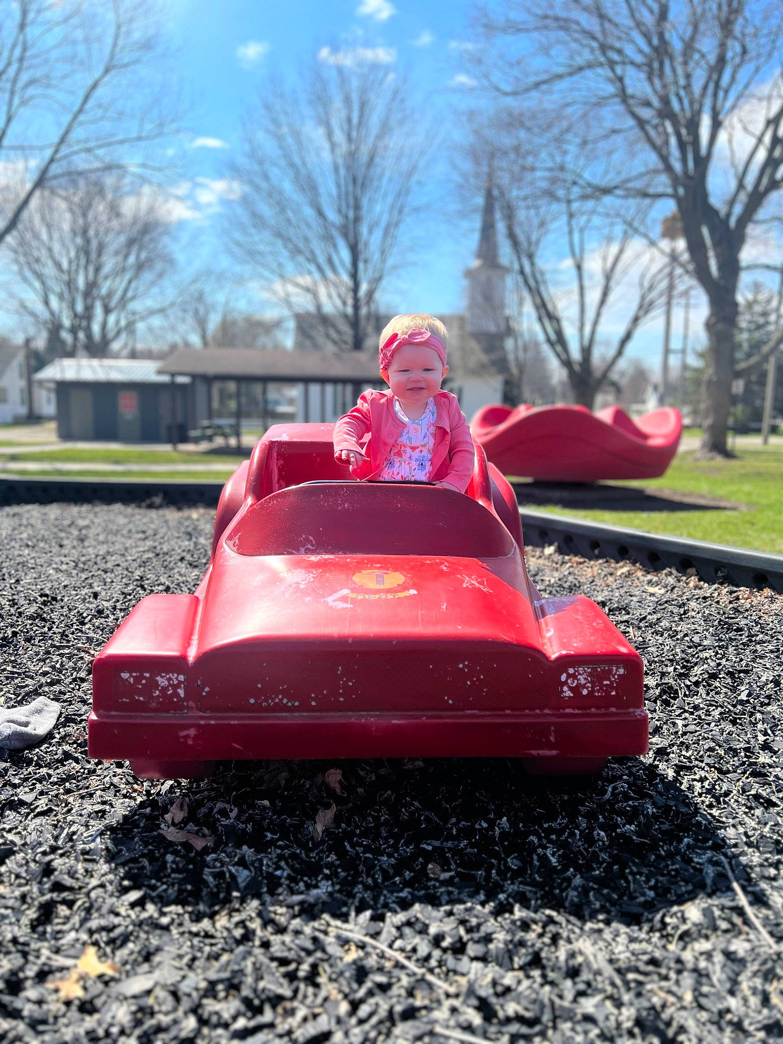 Willow is registered to the contest to win money with this photo: asphalt, automotive_design, automotive_exterior, automotive_wheel_system, bumper, cloud, fun, grass, happy, headwear, joy, leisure, magenta, motor_vehicle, person, plant, recreation, red, sky, toddler