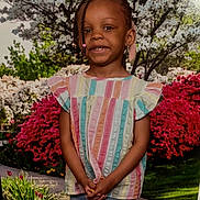 Nafissa is registered to the contest to win money with this photo: beads, braids, child, cute, denim_jeans, flowers, garden, girl, greenery, innocence, nature, outdoor, pastel_colors, pathway, portrait, smile, spring, standing, striped_shirt, young