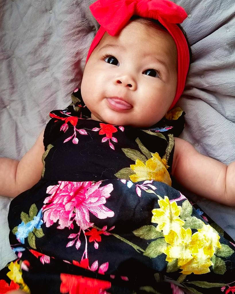 Hendrix is registered to the contest to win money with this photo: baby, cheek, child, costume, fashion_accessory, flower, hair_accessory, headgear, person, pink, plant, toddler